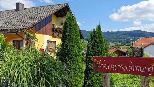 a sign in front of a house with trees at Ferienwohnung Simon In Gleißenberg in Gleißenberg