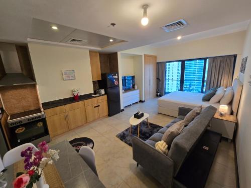 a living room with a couch and a bed at Click Stay - JLT - Entire Studio & Balcony Lakes view Apartment -NA in Dubai