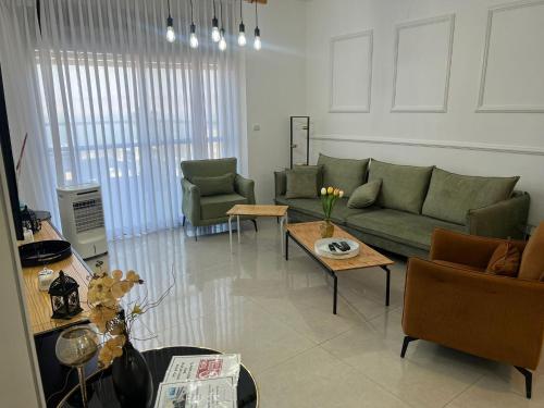 a living room with a green couch and chairs at Kineret sheli- 4Bedrooms luxury apartment with stunning lake view in Tiberias