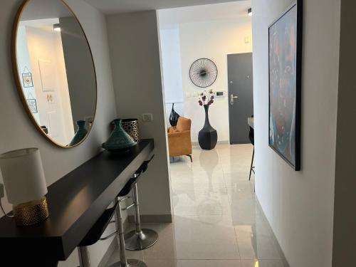 a hallway with a mirror and a table and vases at Kineret sheli- 4Bedrooms luxury apartment with stunning lake view in Tiberias