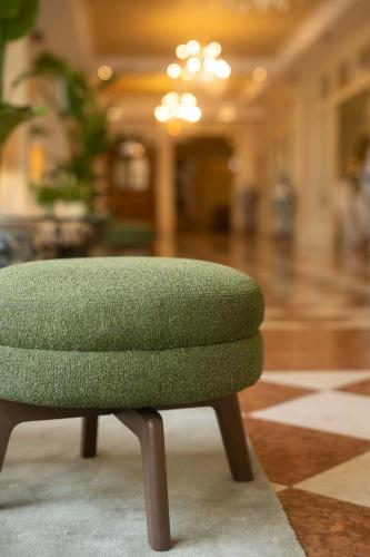 a green ottoman sitting in a room at Grand Hotel Liberty in Riva del Garda