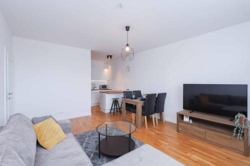 a living room with a couch and a table with chairs at Mozartova- Quiet Getaway with a view of the Danube in Bratislava