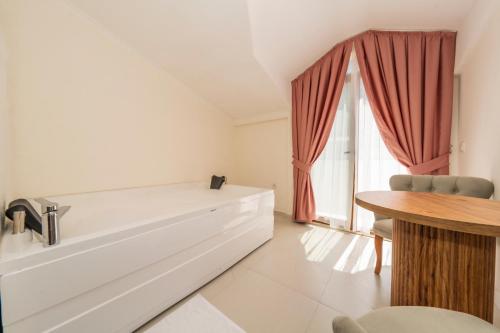 a white room with a table and a window at Katre Hotel Oludeniz in Oludeniz