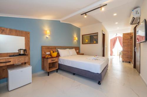 a bedroom with a large bed and a kitchen at Katre Hotel Oludeniz in Oludeniz