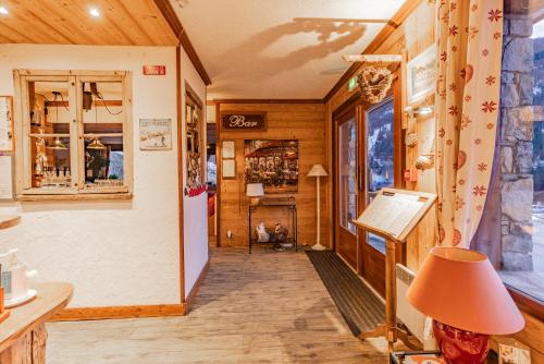 un couloir d'un magasin avec une lampe et une table dans l'établissement Les Glières - Champagny-en-Vanoise, à Champagny-en-Vanoise