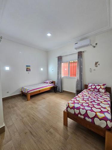 a bedroom with two beds and a window at Maison d'hôte de marque in Pointe-Noire