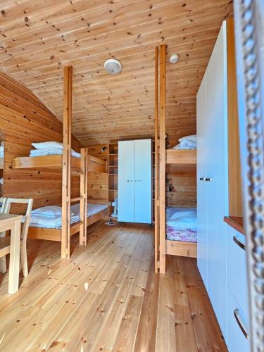 a log cabin bedroom with two bunk beds at Pohjanranta Cottages in Keminmaa