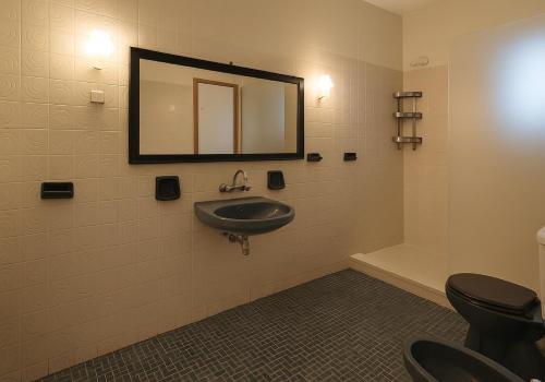 a bathroom with a sink and a mirror and a toilet at The Heraklion City 5 in Mastambás