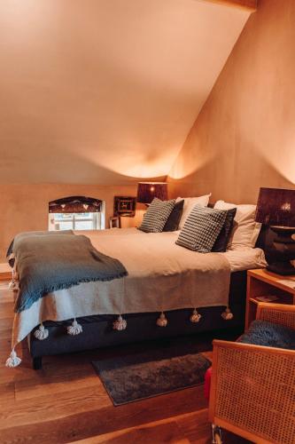 a bedroom with a large bed with pillows on it at Bedandbreakfast De Vallei in Heelsum