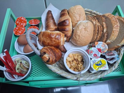 a basket of bread and pastries on a table at La Vie en Rose in Verviers