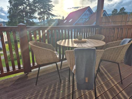 a patio with a table and chairs on a deck at Jen tak Lipno in Lipno nad Vltavou