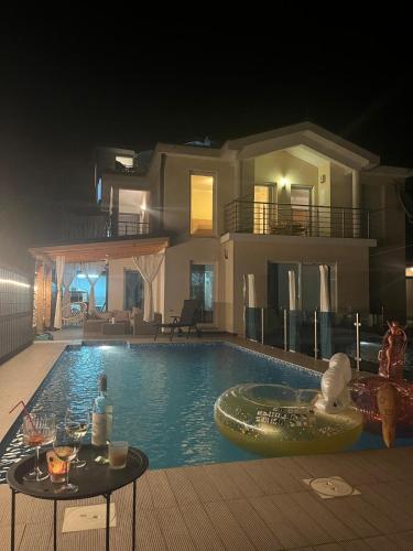 a swimming pool in front of a house at night at Ferienhaus in Široki Brijeg