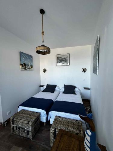 a bedroom with two beds and a pendant light at La vue mer in Yport