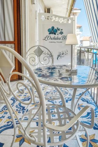 a white table and chairs on a balcony at L'Orchidea Blu in Pianillo