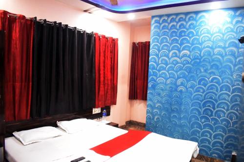 a bedroom with two beds and a blue and red wall at Sigmaa Stay Howrah in Sāntrāgāchi