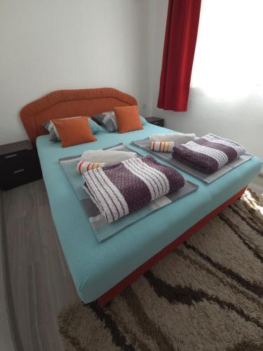 a bed with pillows on it in a bedroom at Guest House Nana in Mostar