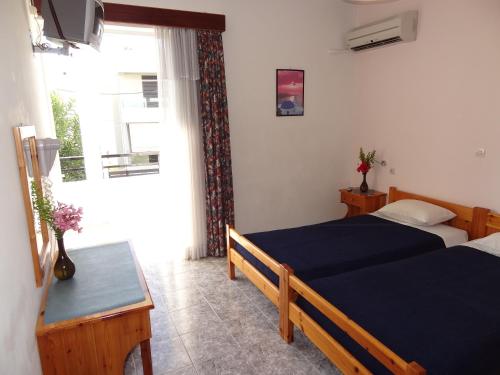 sypialnia z dwoma łóżkami i oknem w obiekcie Michalis Studios & Apartments w mieście Kos