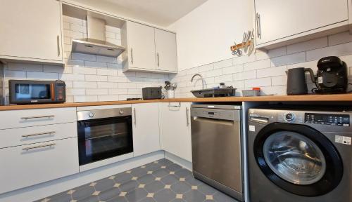 a kitchen with a washing machine and a microwave at The Ransdale in Bridlington