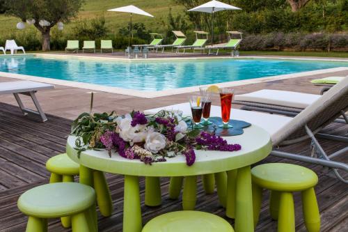 a table with flowers on it next to a pool at Il Giuggiolo - holiday homes in Fossombrone