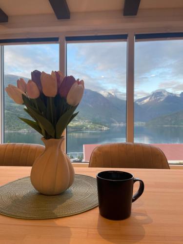 a vase of tulips sitting on a table with a coffee cup at Olden Tinyhouse - Modern Living in Olden
