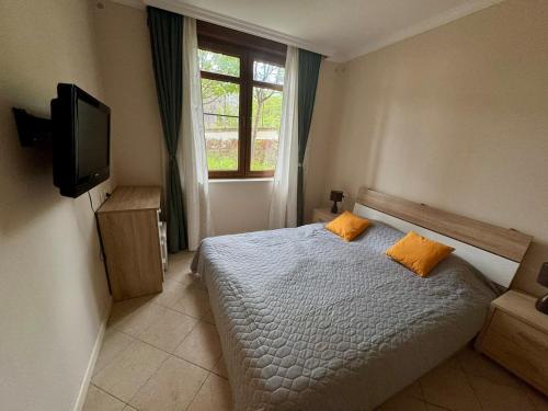 a bedroom with a bed and a tv and a window at Apartment at the Seaside in Sozopol