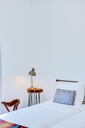 a white bedroom with a bed and a side table at Casa Bom Jardim by Enjoy your stay in Olhão