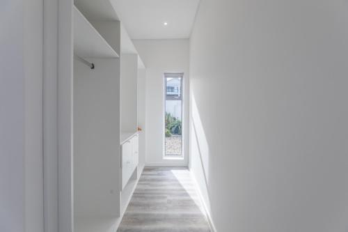 a hallway of a house with white walls and a window at 189 Casa Del Playa in Yzerfontein