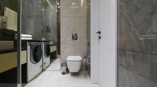 a bathroom with a toilet and a washing machine at Light House 2 in Mekhrably