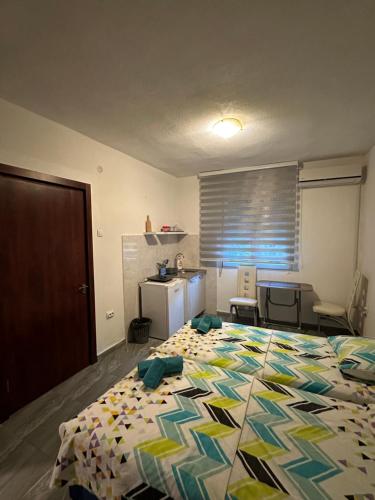 a bedroom with a large bed and a kitchen at Apartmani Rira in Sutomore