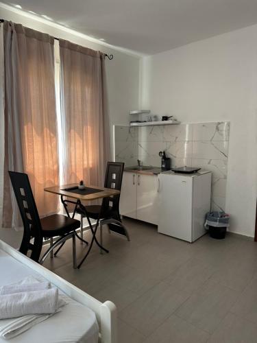 a room with a table and chairs and a kitchen at Apartmani Rira in Sutomore