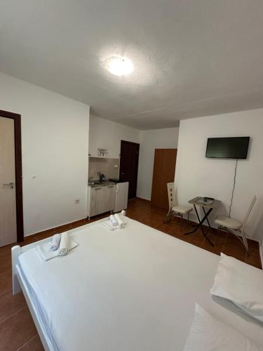 a bedroom with a large white bed and a table at Apartmani Rira in Sutomore