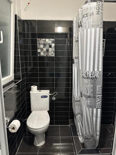 a bathroom with a toilet and a shower curtain at Apartmani Rira in Sutomore