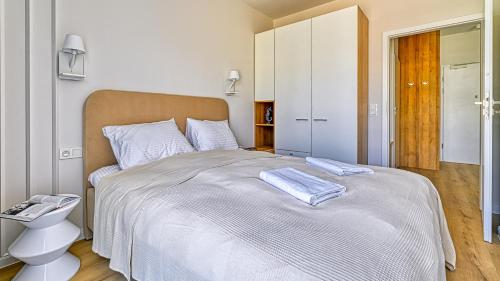 a bedroom with a large bed with two towels on it at Ostseeresidenz Niechorze D305 Eco Boho - 5D Apartments in Niechorze