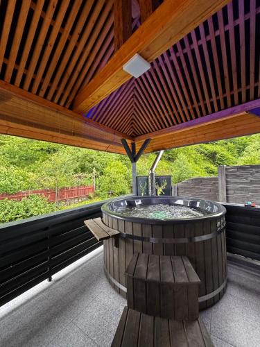 a hot tub in a pavilion with a wooden ceiling at Casa din Vale apartament - Valiug in Văliug