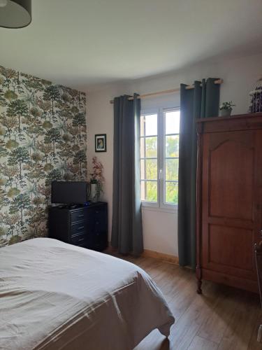 une chambre avec un lit et une fenêtre dans l'établissement L'île Verte chambre avec salle de bain privée, à Champagnac