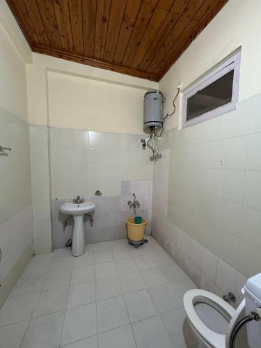 a bathroom with a sink and a toilet at Hotel Swiss Meadows Khajjiar in Khajjiar 
