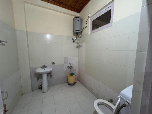 a small bathroom with a sink and a toilet at Hotel Swiss Meadows Khajjiar in Khajjiar 
