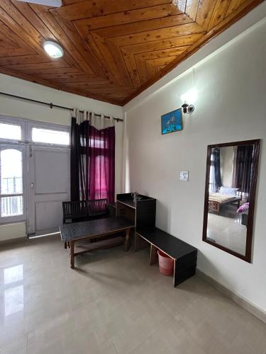 a living room with a bench and a mirror at Hotel Swiss Meadows Khajjiar in Khajjiar 