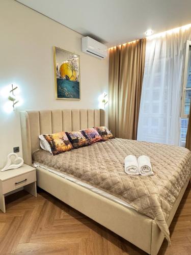 una camera da letto con un letto grande con due asciugamani sopra di Центр города 2 room meridian apartments super new modern a Almaty