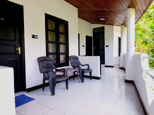 a room with chairs and a table in a house at Rea Beach Way Hotel in Trincomalee