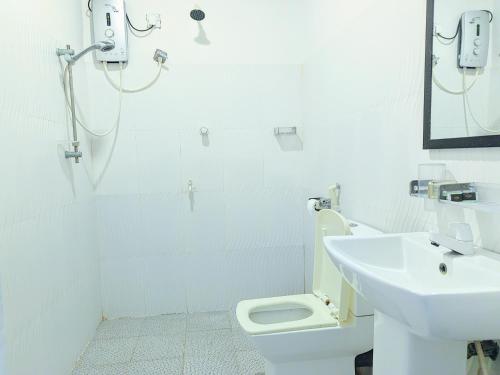 a bathroom with a shower and a sink and a toilet at Rea Beach Way Hotel in Trincomalee
