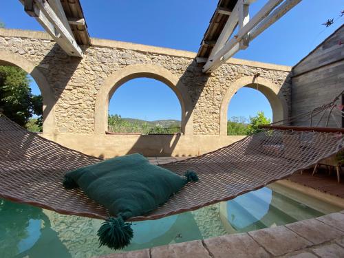 un hamac suspendu au-dessus d'un bassin d'eau dans l'établissement Magnifique et grande maison 5 mn mer dans nature, à Narbonne