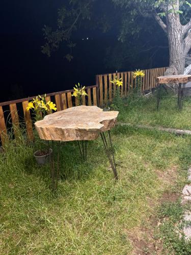 a wooden table sitting in the grass near a fence at Old Byurakan Cottage in Byurakan