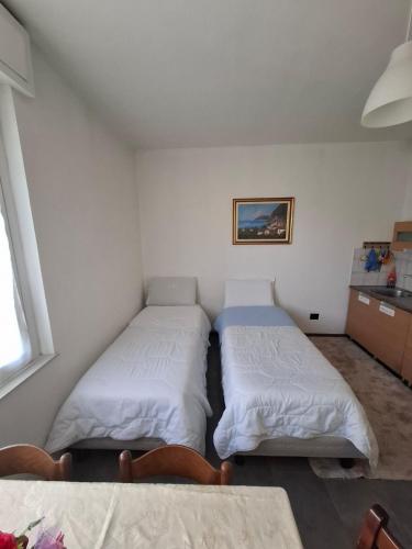 a room with two beds and a table in it at Fly & Rest BGY in Zanica