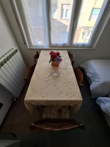 a table with a vase of flowers on it in front of a window at Fly & Rest BGY in Zanica