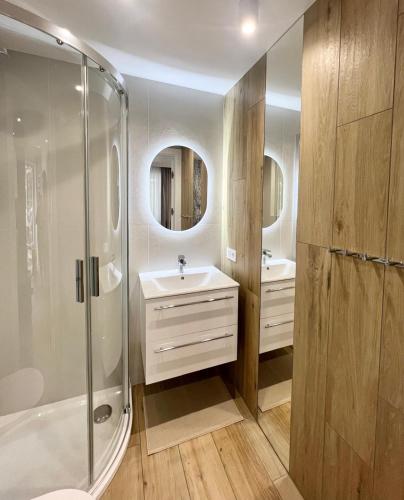 a bathroom with a shower and a sink at Apartamenty Solano - wybrane z widokiem na morze in Rowy