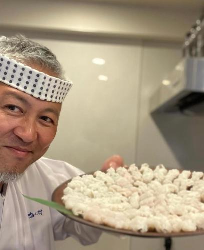 a chef is holding a cake on a tray at 京都観光に最適 ペットok 名神東インターから1分 3LDK無料駐車場付 京都駅から1駅 山科駅周辺 蹴上インクラインまで10分 in Kyoto