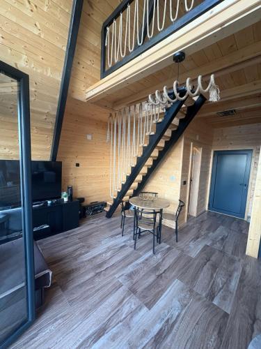 a dining room with a table and a staircase at A Frame Vila sa Saunom Jakuzii i toplim bazenom in Koraćica