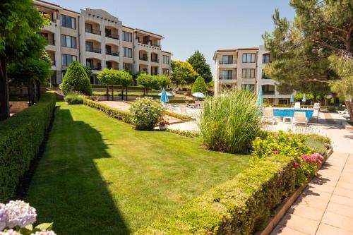 un jardín con césped frente a un edificio en Apartment in Paradise View complex, en Sozopol