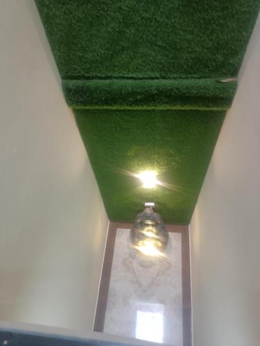 a green ceiling with a light in a room at Hotel Noble Stays in Mohali